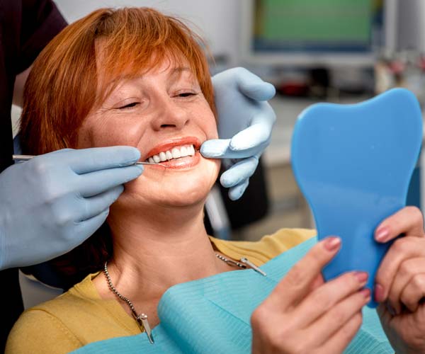 Woman SMiling with Full Mouth Dental Implants at Dentist